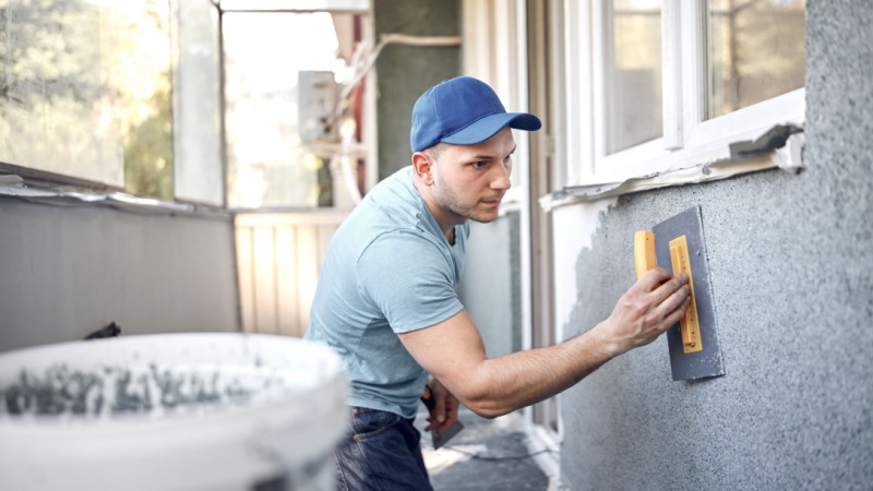 Operaio con spatola ristruttura un balcone